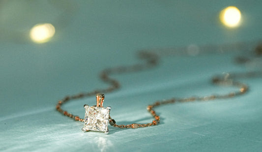 close up of diamond necklace resting on blue background