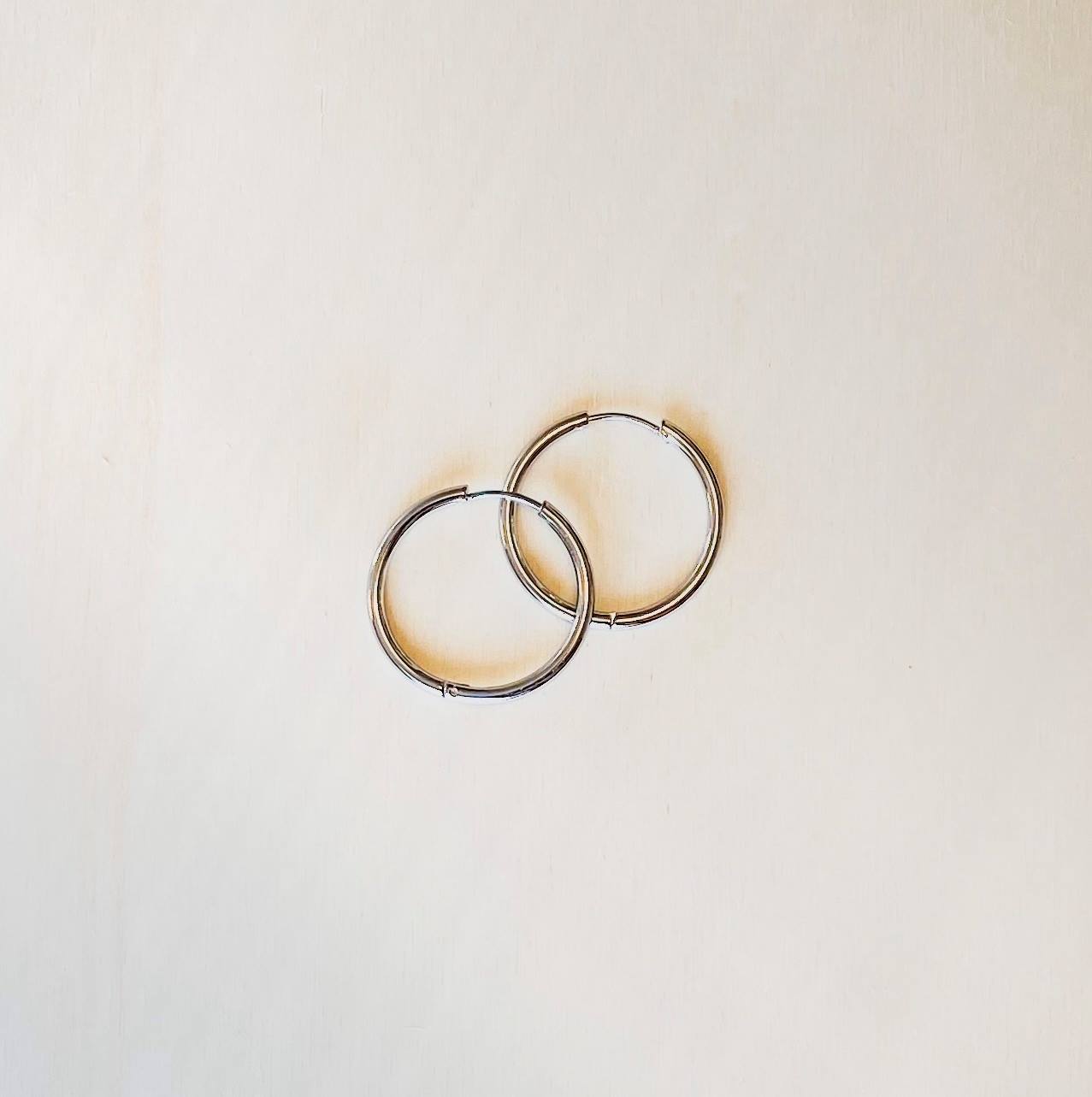 silver hoops earrings on plain white background.