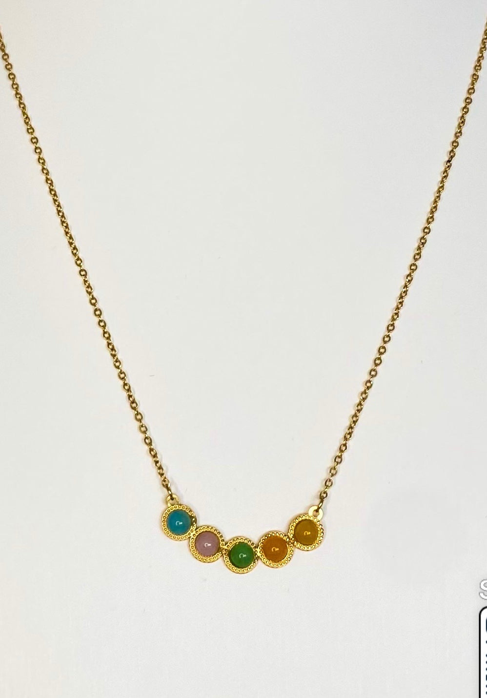 five stone pendant necklace, gold plated with colours blue pink green orange and yellow on plain white background