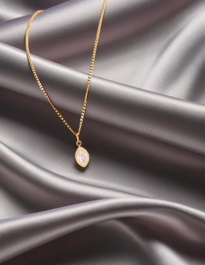 gold marquise zirconia stone pendant on silk background