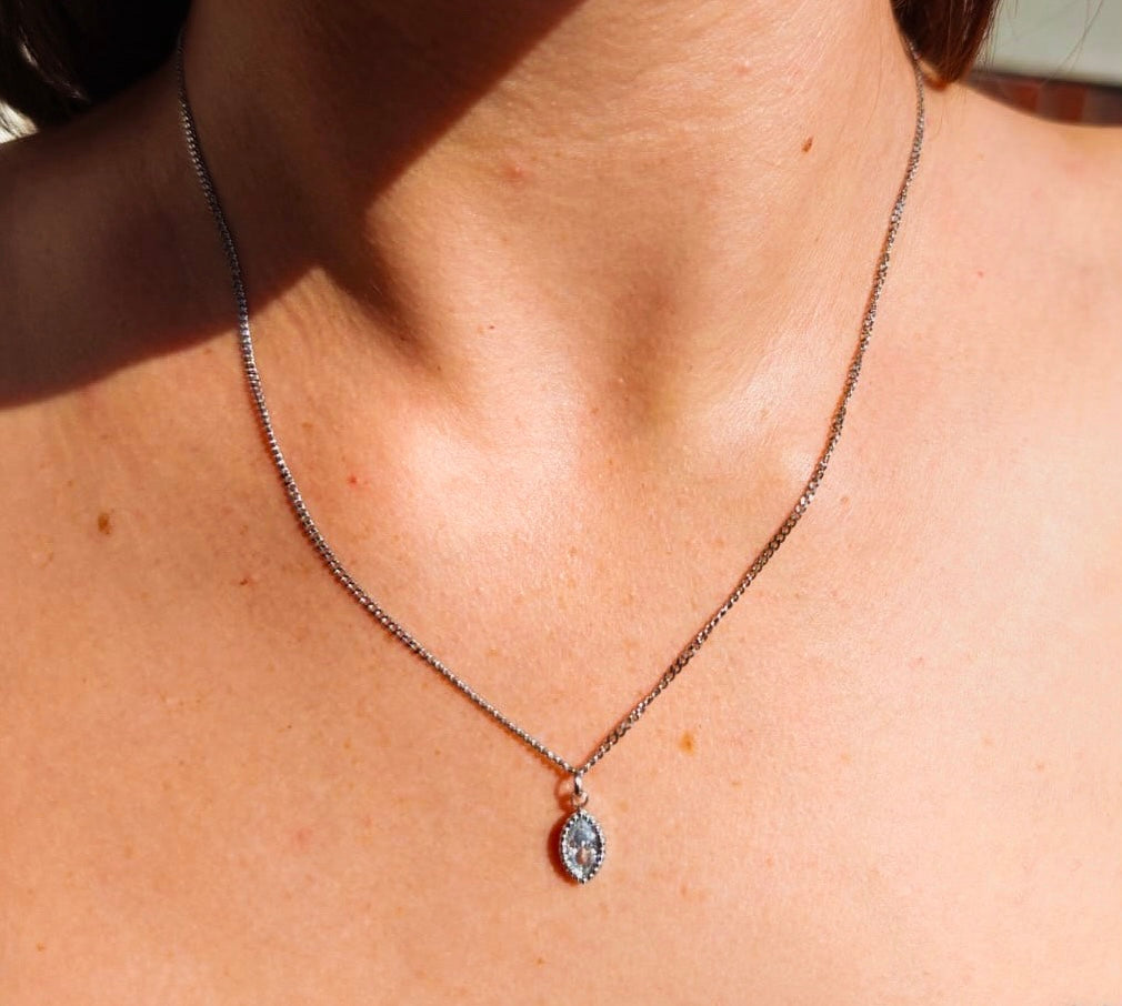 brunette model wearing a silver marquise cut diamond necklace in the sunshine